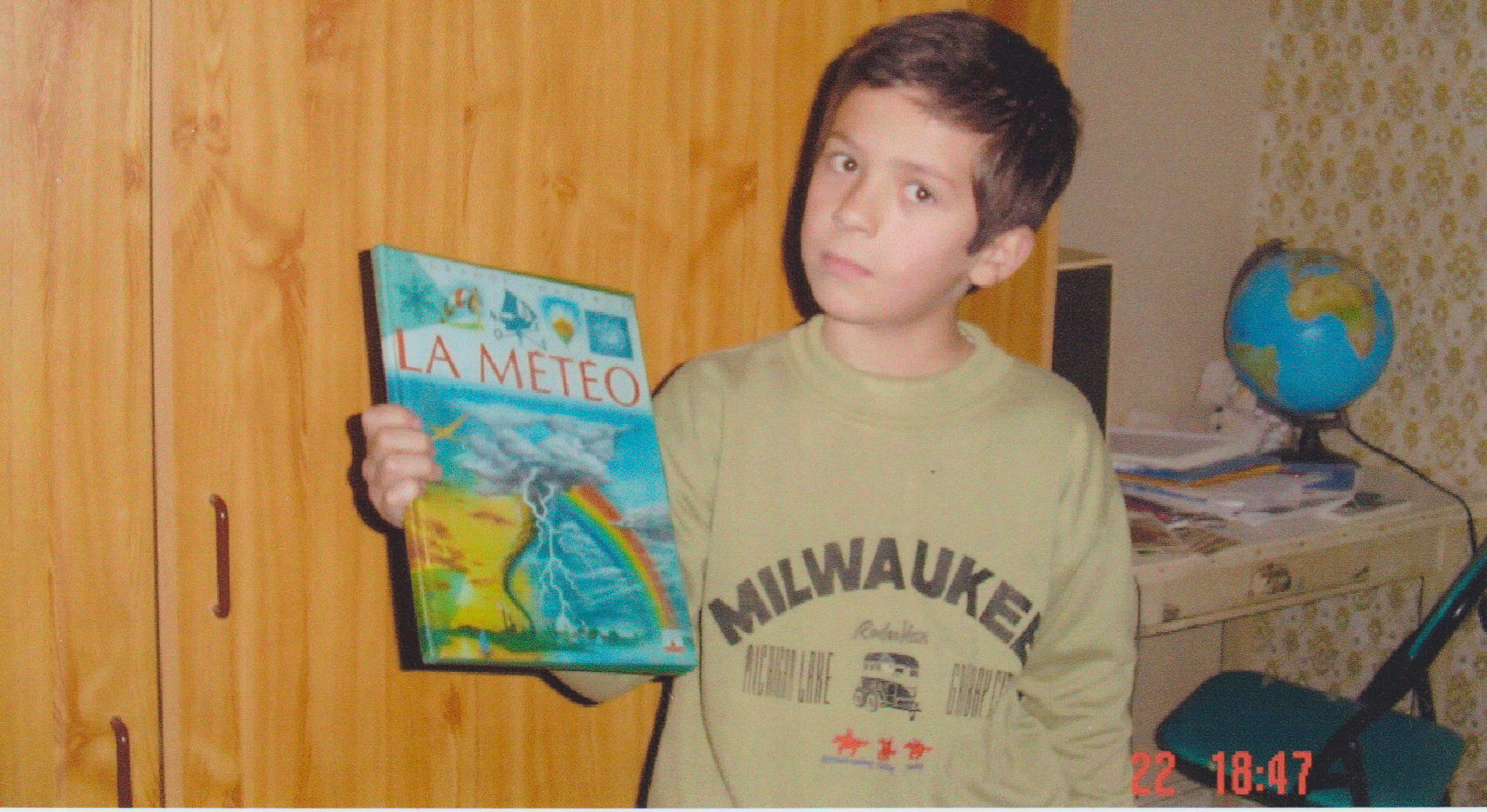 Mickael Grandjean tenant un livre de météo à l'âge de 9 ans